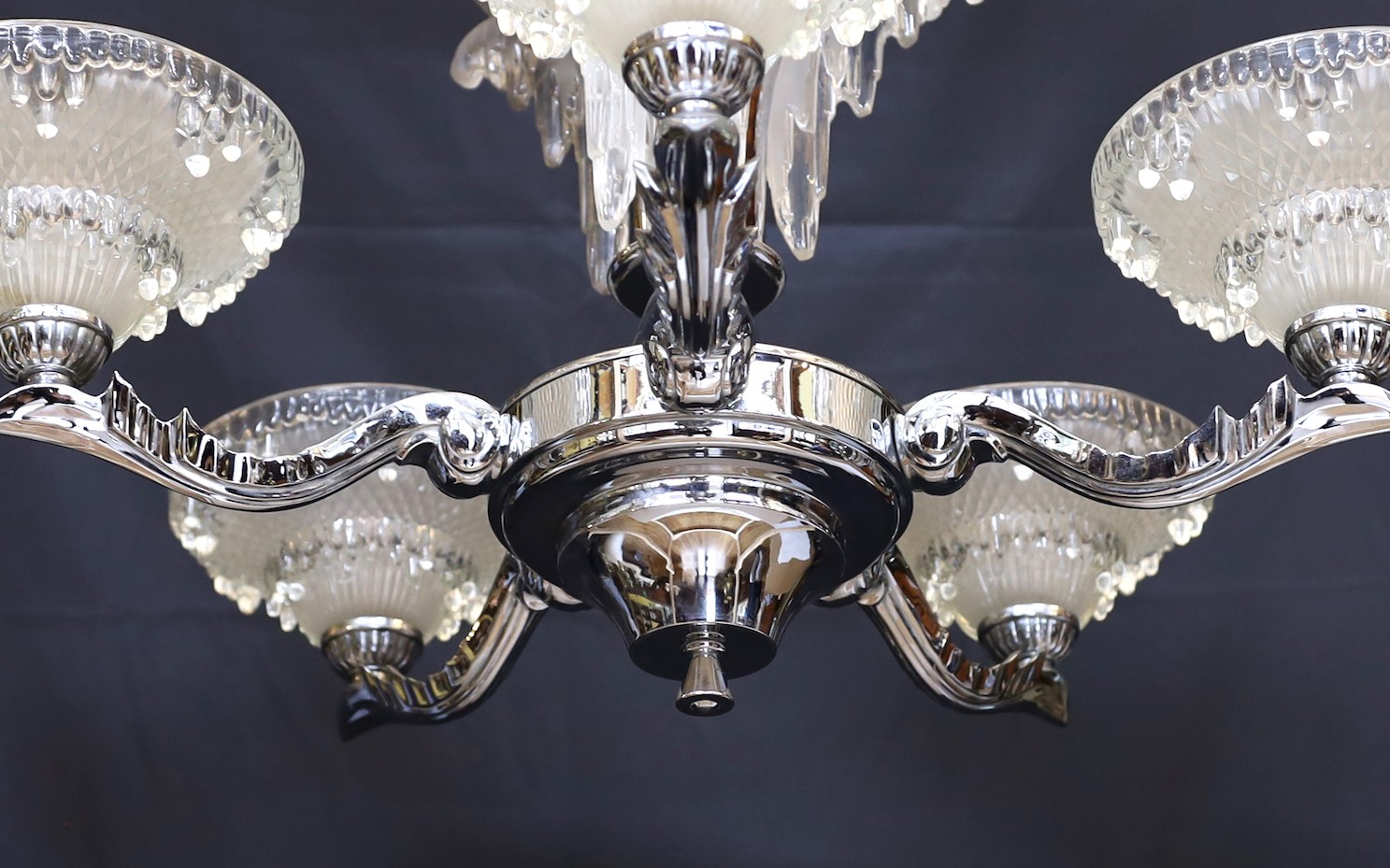 A French Art Deco chrome plated and glass five light chandelier, with scrolling branches and 'melting ice' mounts and shades, drop 85cm. width 70cm